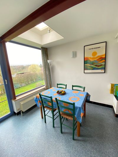 The bright dining area with windows overlooking the countryside — the sunset here is stunning